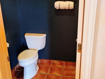 Small bathroom with white toilet and dark blue walls.
