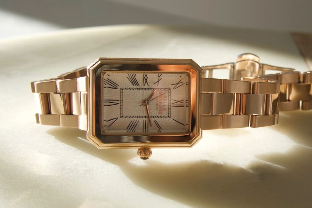 ladies gold watch on marble surface