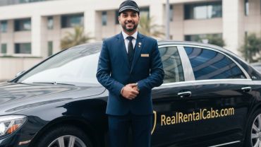 Professional chauffeur in uniform standing beside a luxury rental car.