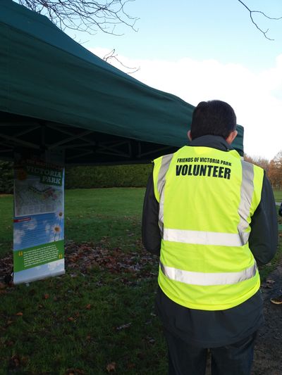 Person wearing a hi-vis vest with the words Friends of Victoria Park Volunteer on it.