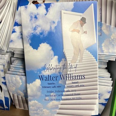 Funeral memorial programs with blue sky and cloud design stacked after printing and folding producti