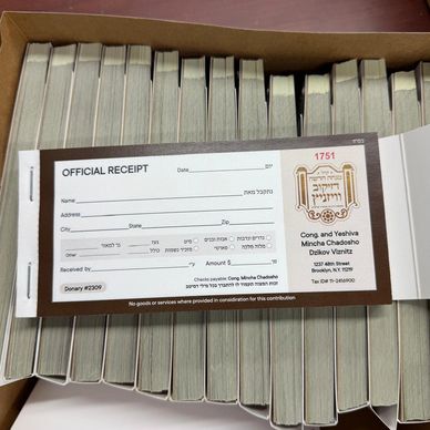 Printed carbonless invoice receipt books stacked in a box with custom numbering and perforated dupli