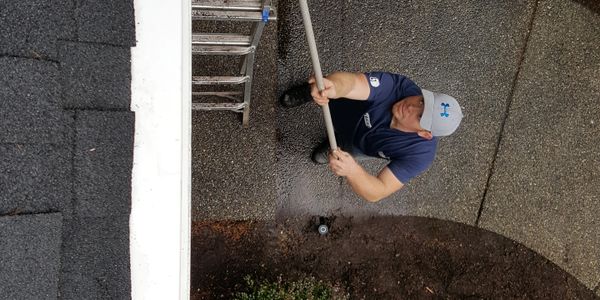 Exterior gutter cleaning to remove moss and algea  on a house after Cleaning The Roof