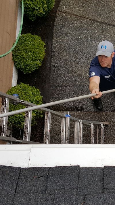 Scrubbing the exterior of gutters after cleaning the roof in Bothell Washington