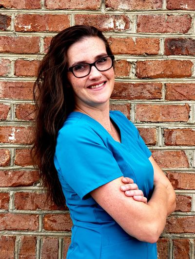 Lindsey Akins, LPN standing with her arms crossed while smiling