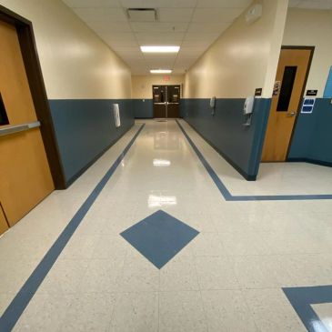 Empty school hallway with blue and gray walls.