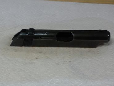 Black metal slide of a semi-automatic pistol on a white surface.