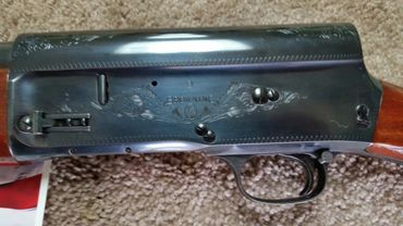 Close-up of a Browning shotgun receiver with engraved floral designs.