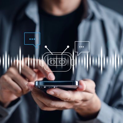 Hands holding a phone with a speech bubble, sound waves, and a chatbot icon.