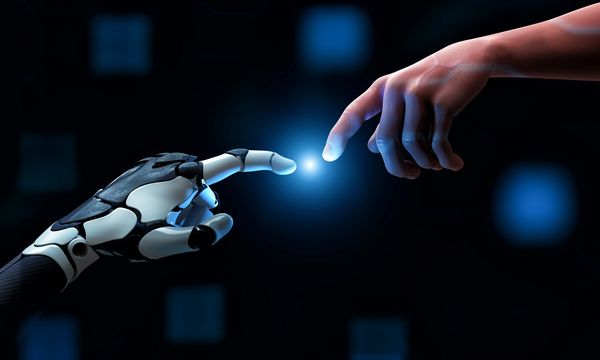A human finger and a robot finger reaching out to touch, with a glowing light between them.