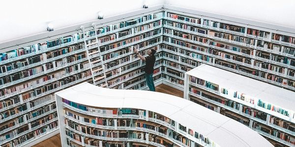 Man conducting research in a large, white, curved library.
