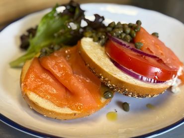 Bagel sandwich with smoked salmon, tomato, red onion, capers, and lettuce.