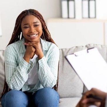A woman smiling during a counseling session.