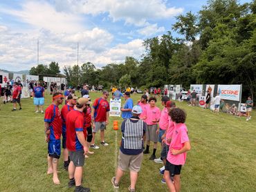 People standing on the kickball field with referree