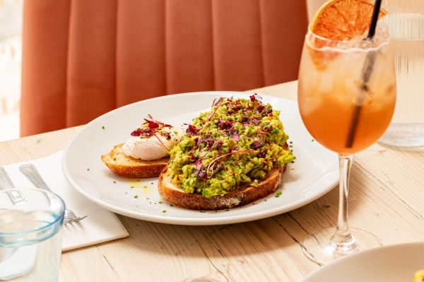 Avocado toast with poached egg and a cocktail.