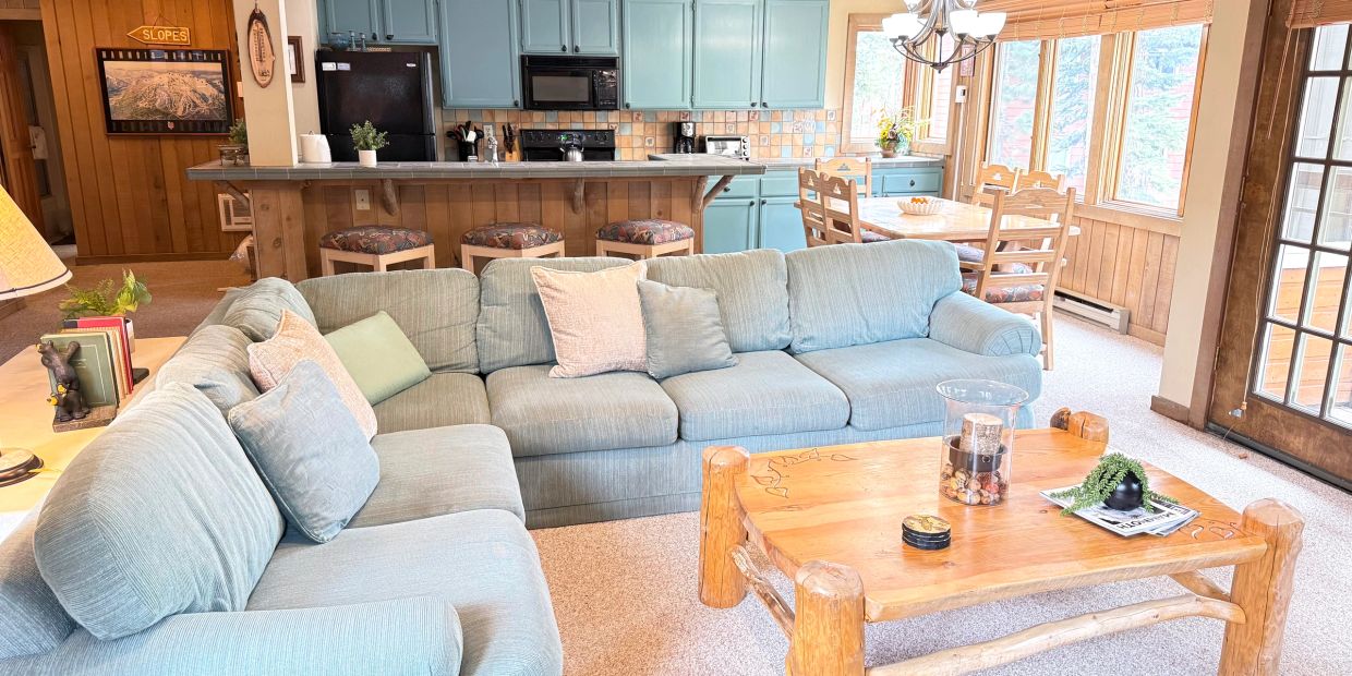 Cozy living room with light blue sofas and wooden coffee table.