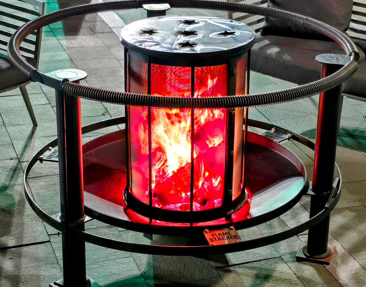 Outdoor flame stacker heater glowing with warm firelight.