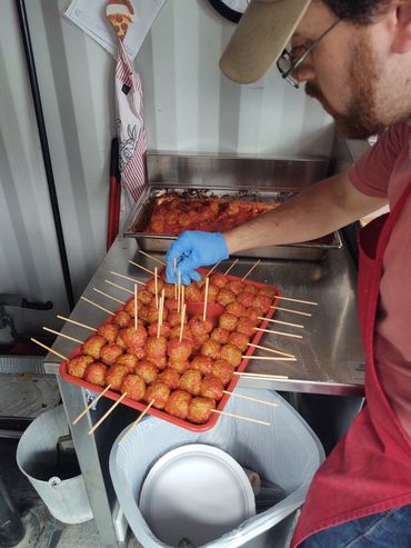Nick assembling food for a large event, catered by a pizza food truck in the Chicago area