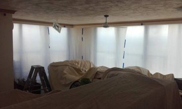 Room covered in protective sheets for painting or renovation.