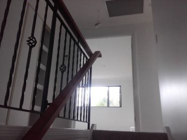 Staircase with black railing and window at the top.