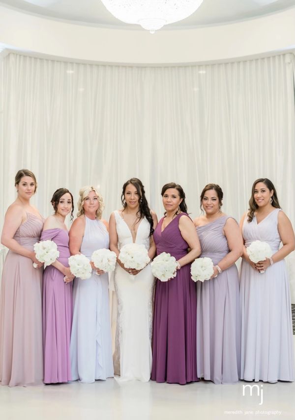 Brides wearing white wedding gowns carrying floral bouquets