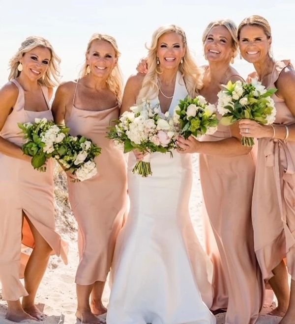 5 women wearing wedding dresses holding a bunch of white flowers in their hands