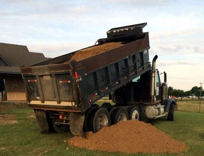 Truck from JNB hauling and dumping a load of topsoil and fill dirt at a project in Sanger, Texas.