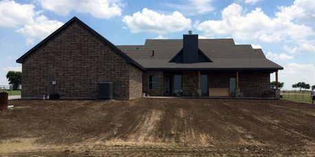 Fill dirt and topsoil installed for positive drainage at a new home in Sanger, Texas.