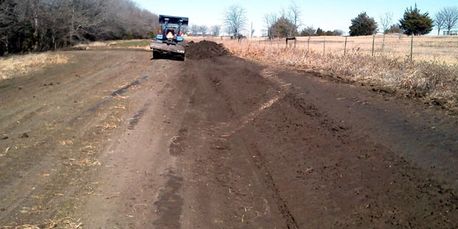 Drainage swale grading for stormwater runoff in Gunter, Texas.