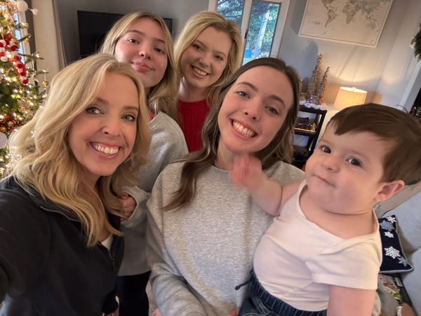 A happy group selfie with three young women and a baby.