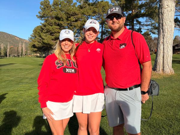 A family dressed in red golf attire posing outdoors.