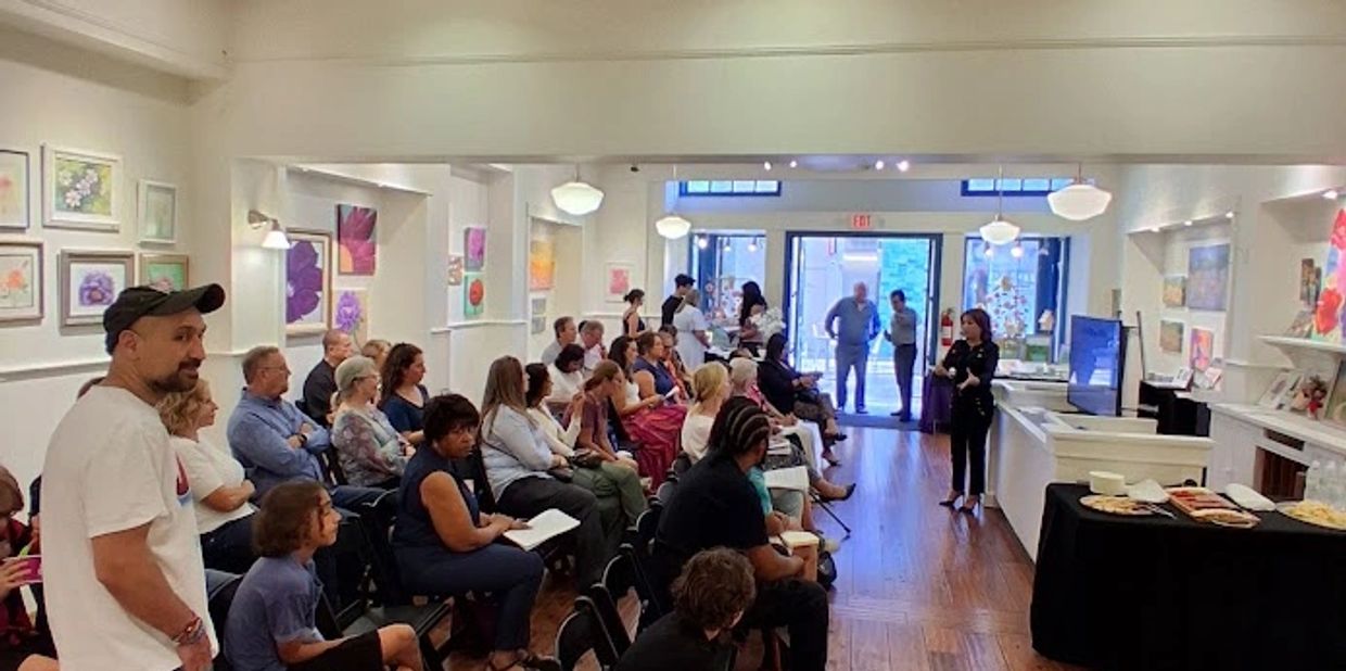 People attending a presentation in an art gallery.