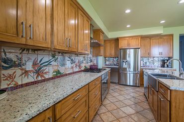 A view of the beer tap, stainless steel appliances, and ample workspace.