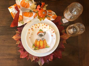 Autumn table place setting with kitten in a pumpkin