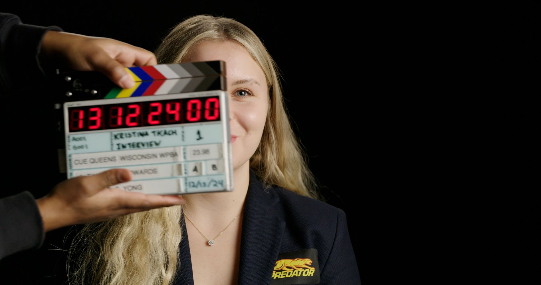 Billiards player Kristina Tkach smiles as a film slate claps in front of her.