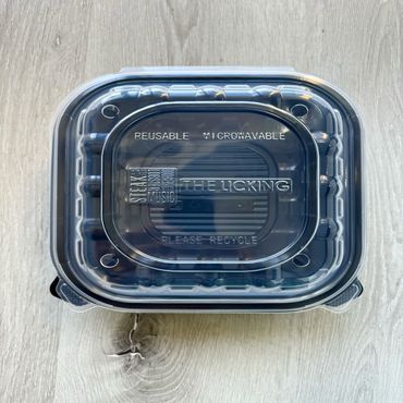 Square black takeout container with a custom embossed lid