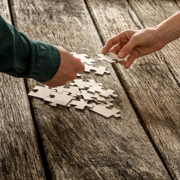 A man and woman putting together a jigsaw puzzle