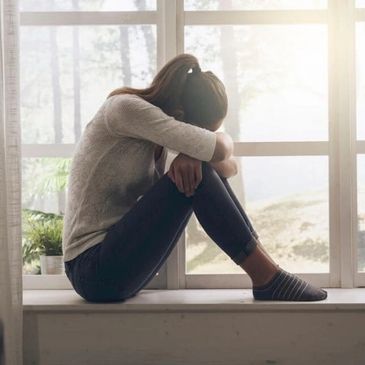 A woman sitting on a window sill