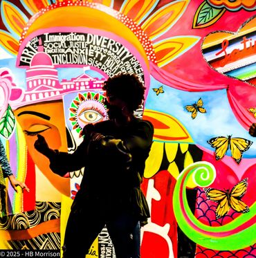 Silhouetted person dancing in front of vibrant mural with social justice themes and butterflies.