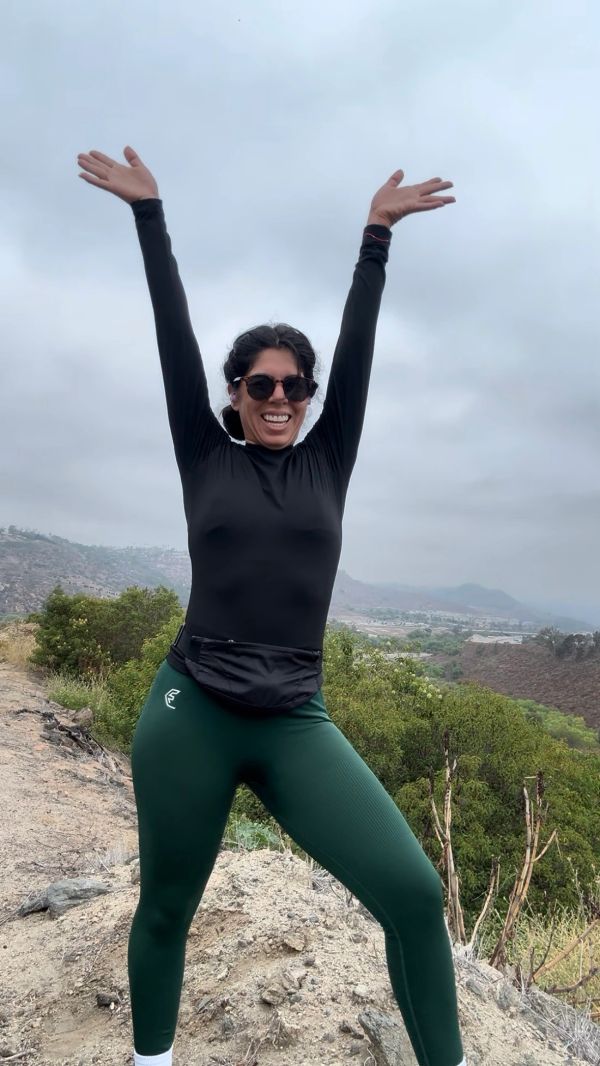 Woman raising arms happily outdoors.