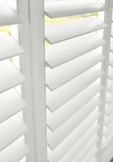Close-up of white plantation window shutters.