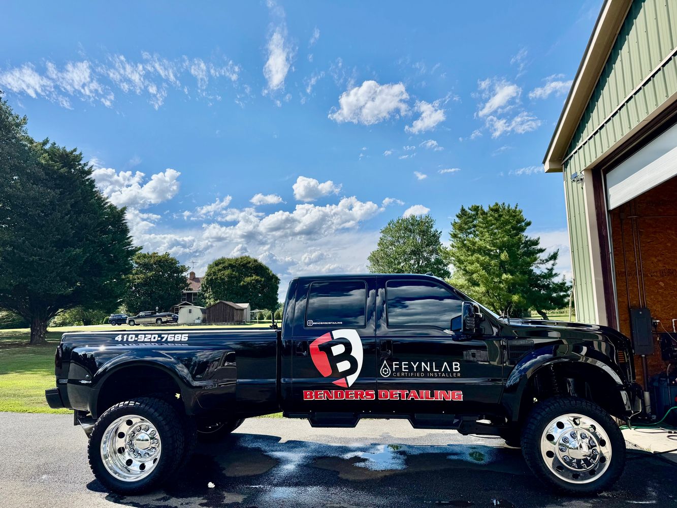 Black pickup truck with Benders Detailing branding parked outside a garage.