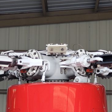 Close-up of a helicopter rotor hub with mechanical components.