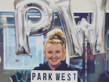 Photo of a woman holding a Park West sign
