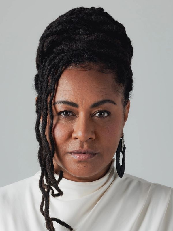 Confident woman with braided hair wearing a white turtleneck.