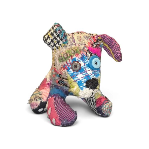 Hand stitched puppy dog covered in fabric, embroidery and vintage textiles.