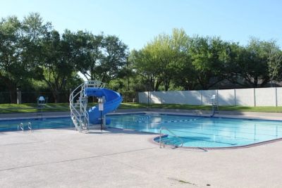 Empty outdoor swimming pool with a blue slide.
