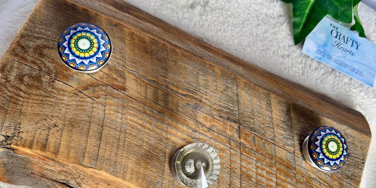 Wooden board with three colorful decorative knobs and a business card.