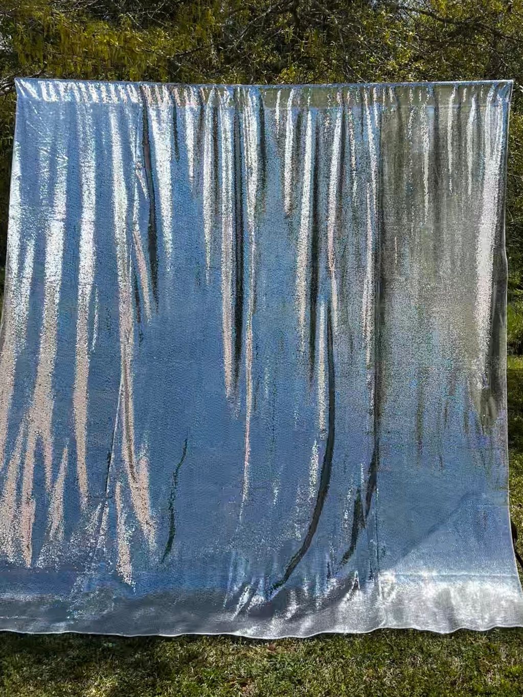 Silver sequined back drop displayed on black backdrop stand