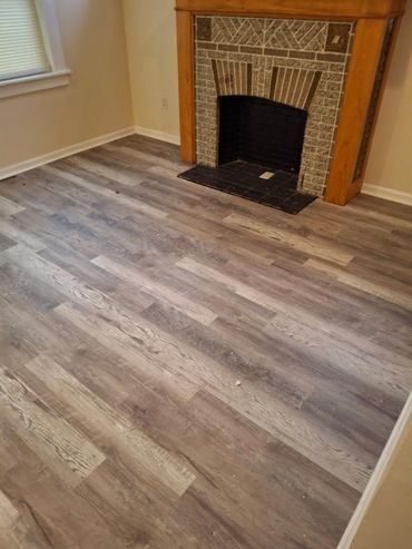 “New flooring installed around a living room fireplace.”